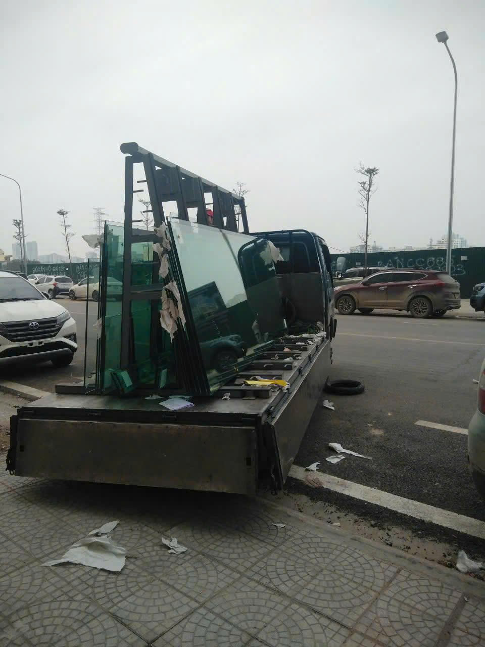 Các tấm kính được xếp trên xe chuyên dụng tại điểm giao hàng ban ngày